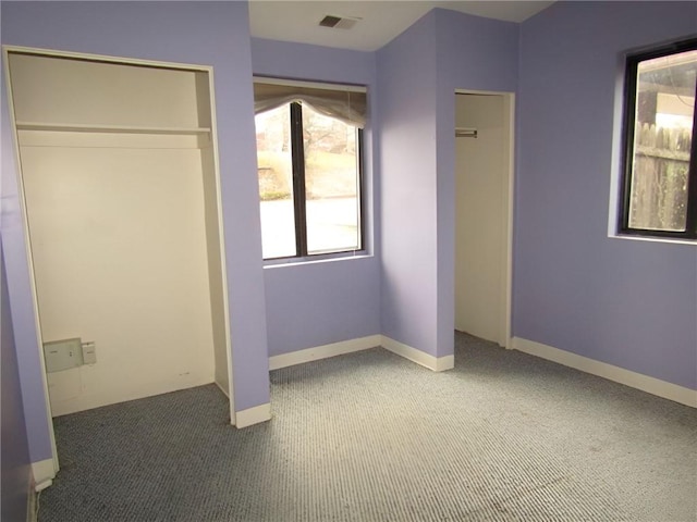 unfurnished bedroom featuring dark colored carpet and a closet