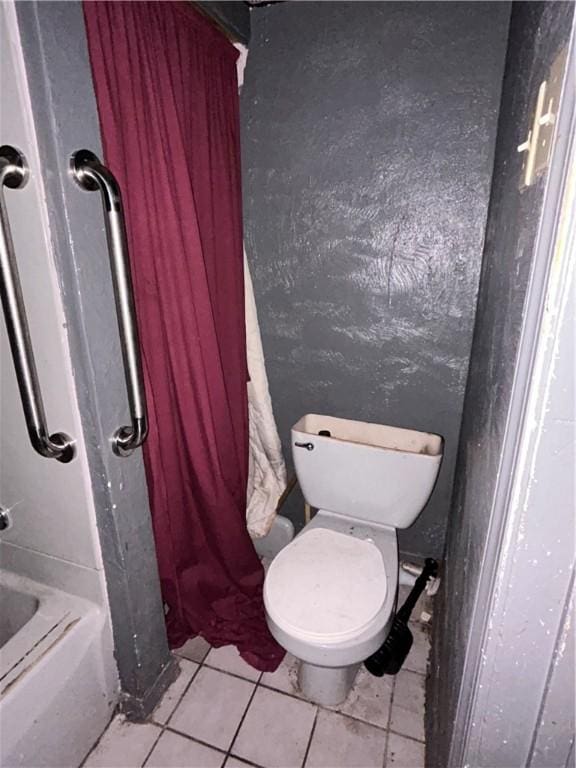 bathroom featuring walk in shower, tile patterned flooring, and toilet