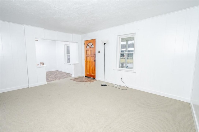 carpeted empty room with a textured ceiling