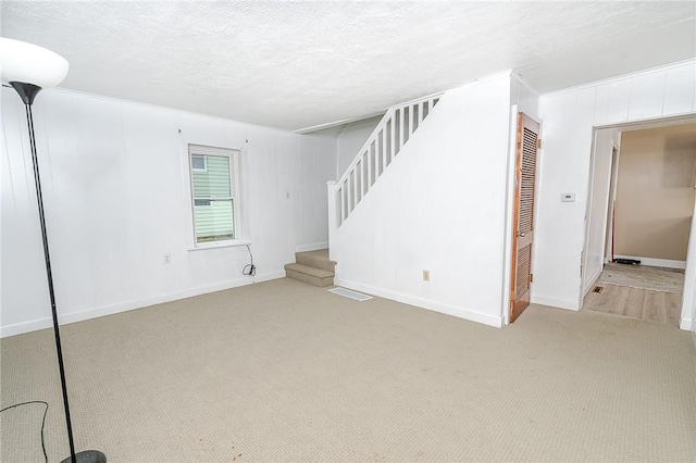 interior space featuring light carpet and a textured ceiling