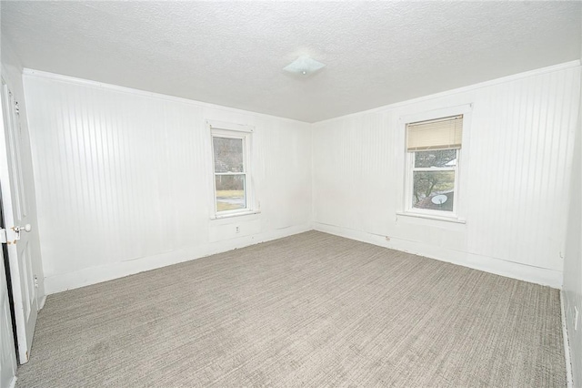 empty room with a textured ceiling and light carpet