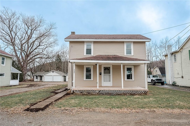 front of property with a garage, an outbuilding, and a front yard