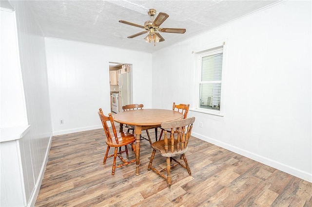 dining area with hardwood / wood-style flooring, ceiling fan, and a textured ceiling