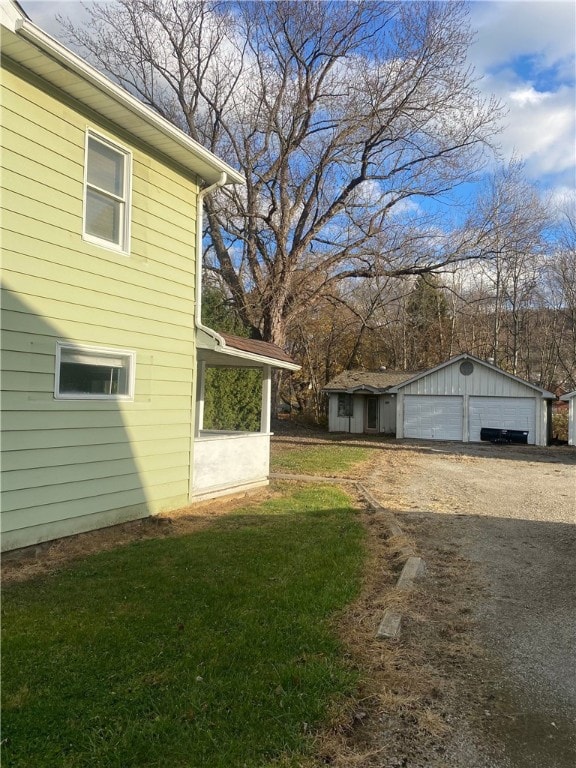 view of side of property featuring a garage, an outbuilding, and a yard