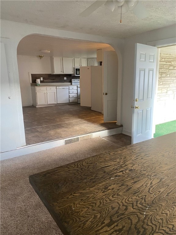 kitchen with white cabinets, a textured ceiling, white appliances, and ceiling fan