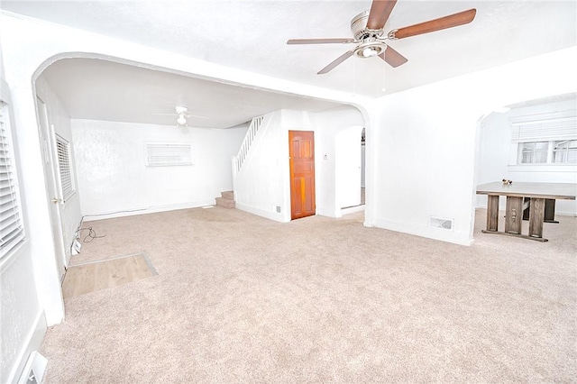 unfurnished living room with light carpet and ceiling fan