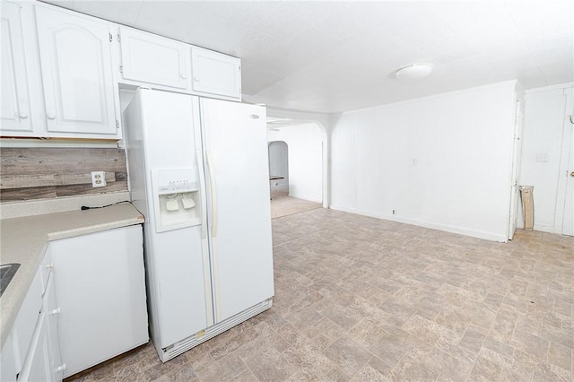 kitchen featuring white cabinets and white fridge with ice dispenser