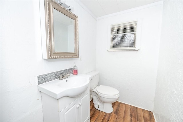 bathroom featuring crown molding, vanity, wood-type flooring, and toilet