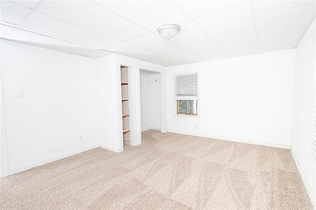 unfurnished room with a paneled ceiling and carpet flooring