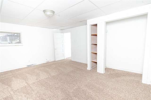 basement featuring carpet and a drop ceiling