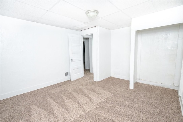 basement featuring a paneled ceiling and carpet flooring