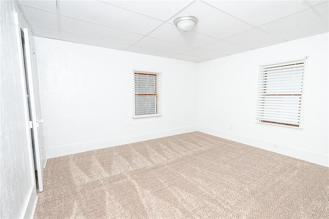 empty room with a paneled ceiling and carpet floors