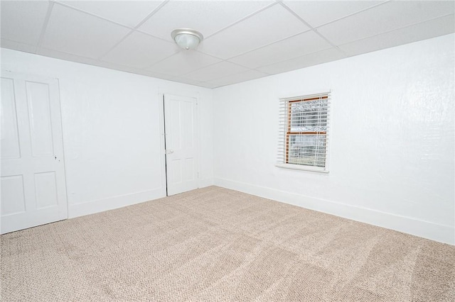 carpeted spare room with a drop ceiling