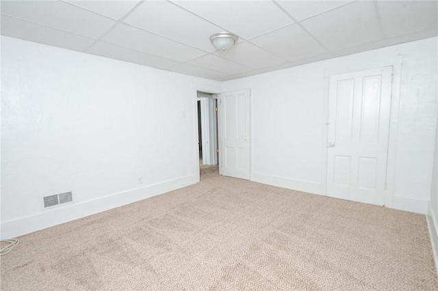 empty room featuring carpet flooring and a drop ceiling