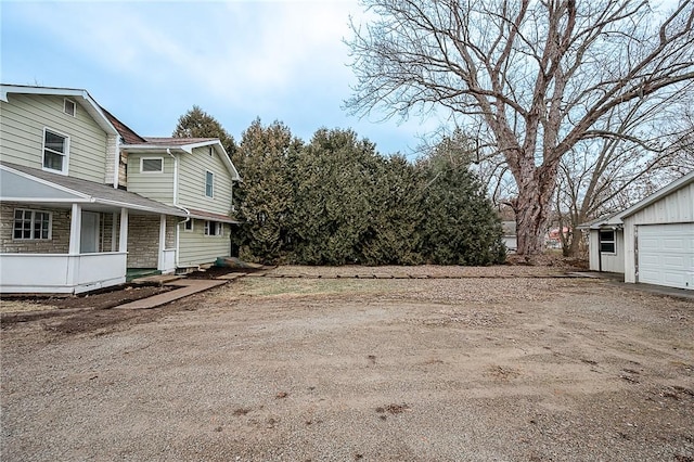 view of yard with covered porch, an outdoor structure, and a garage