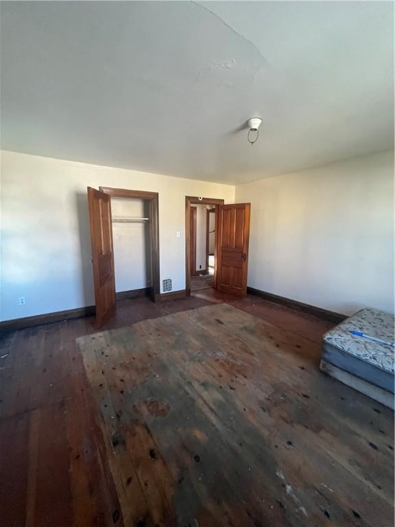 unfurnished bedroom with dark wood-type flooring