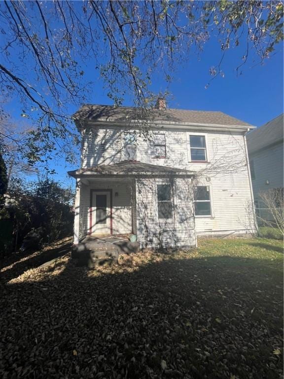 rear view of property featuring a yard