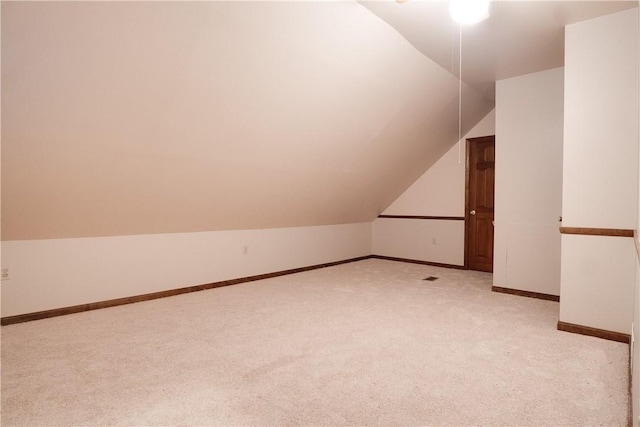 bonus room with light colored carpet and lofted ceiling