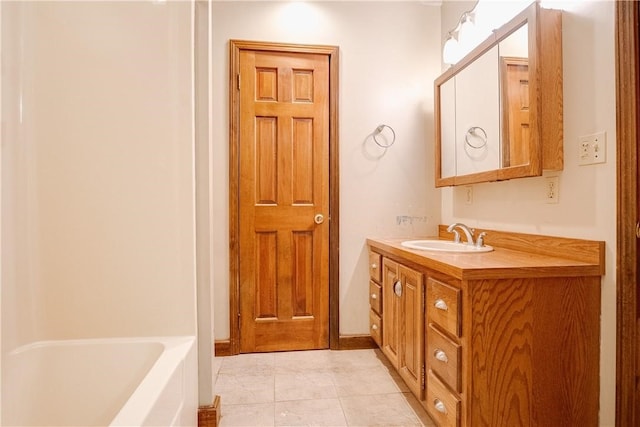 bathroom with tile patterned floors, a washtub, and vanity