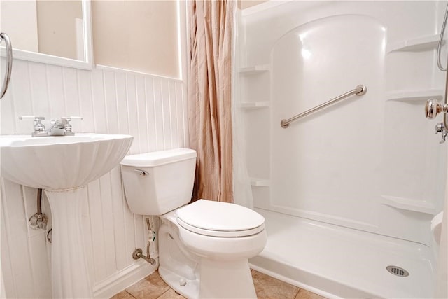 bathroom featuring toilet, tile patterned floors, and curtained shower