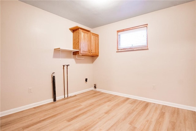 washroom featuring cabinets, light wood-type flooring, and hookup for a washing machine