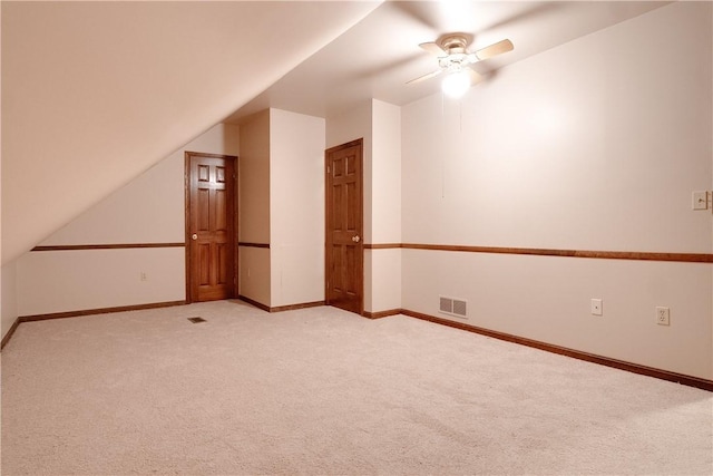 additional living space featuring ceiling fan, light colored carpet, and lofted ceiling