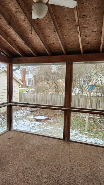 unfurnished sunroom with lofted ceiling with beams