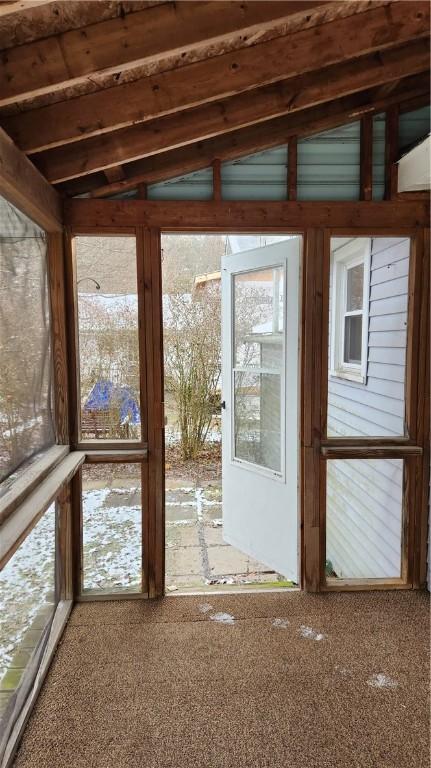 unfurnished sunroom with lofted ceiling with beams