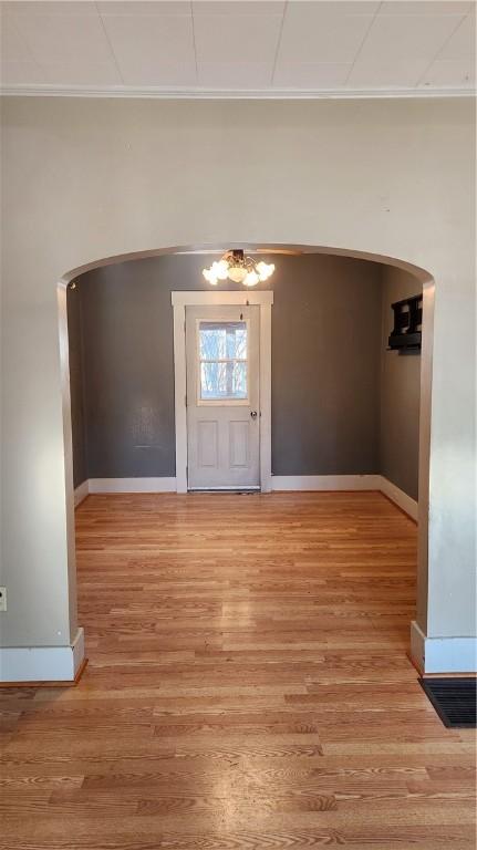 foyer entrance featuring crown molding and hardwood / wood-style flooring