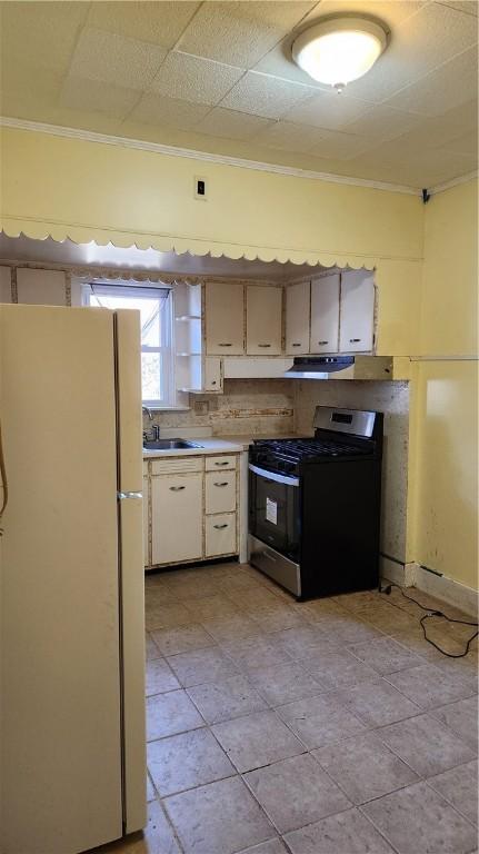 kitchen featuring white cabinets, crown molding, sink, white fridge, and gas stove