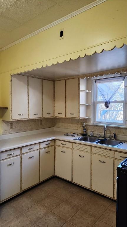 kitchen with black / electric stove, crown molding, sink, and white cabinets