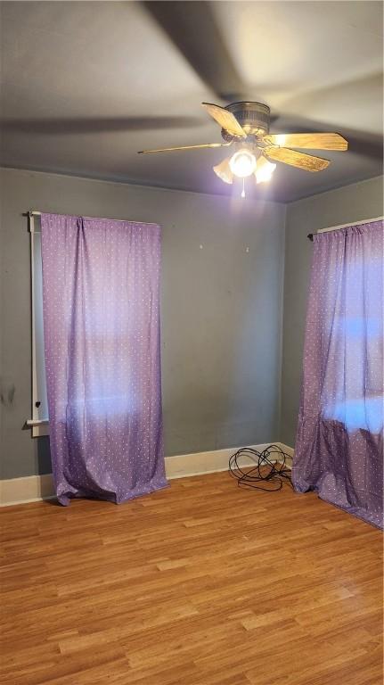 empty room with ceiling fan and light hardwood / wood-style floors