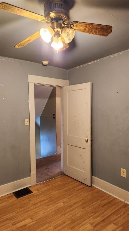 empty room with light hardwood / wood-style floors and ceiling fan