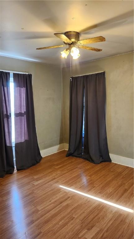 unfurnished room featuring hardwood / wood-style floors and ceiling fan