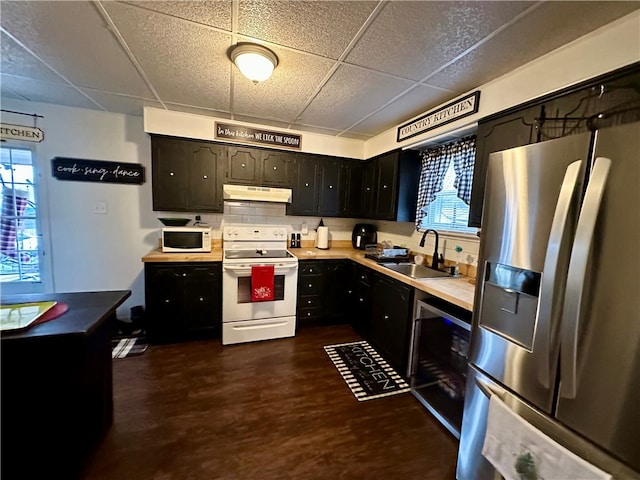 kitchen featuring a wealth of natural light, a paneled ceiling, sink, and white appliances