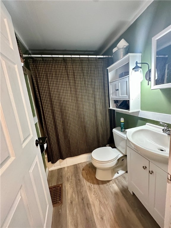 bathroom with toilet, a shower with curtain, hardwood / wood-style floors, and vanity