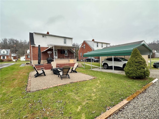 rear view of house featuring a lawn and a carport