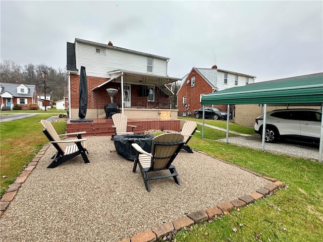 back of property featuring covered porch, a carport, and a lawn