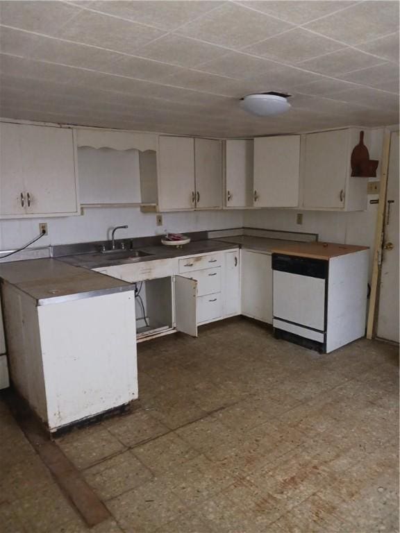 kitchen featuring white cabinetry, sink, and fridge