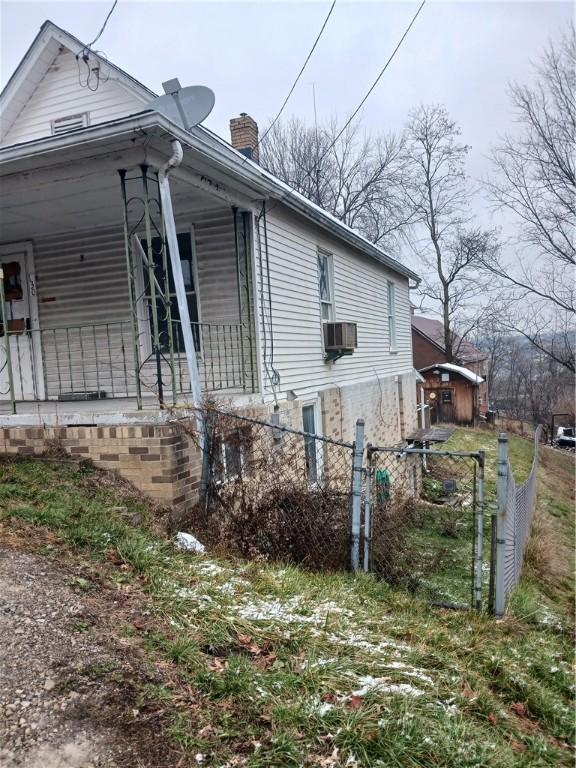 view of property exterior with a porch and cooling unit