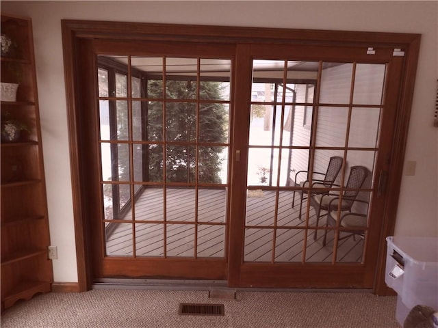 doorway to outside featuring carpet flooring