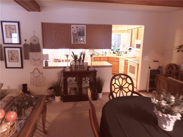 dining area with beamed ceiling and light carpet