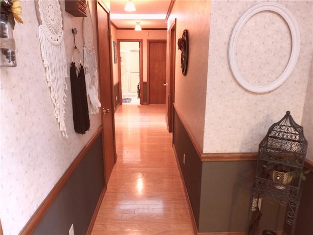 hallway featuring light hardwood / wood-style floors and ornamental molding