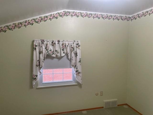 carpeted empty room featuring visible vents and baseboards