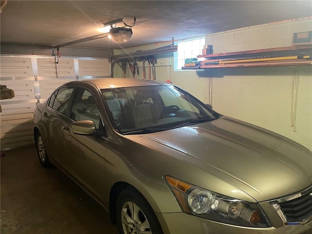 garage featuring a garage door opener and concrete block wall