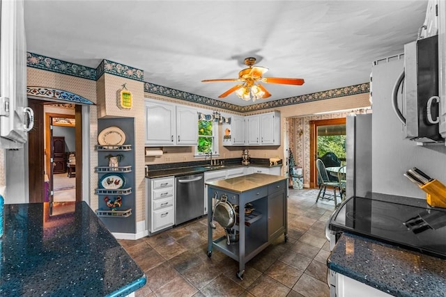 kitchen featuring a wealth of natural light, ceiling fan, white cabinetry, and appliances with stainless steel finishes