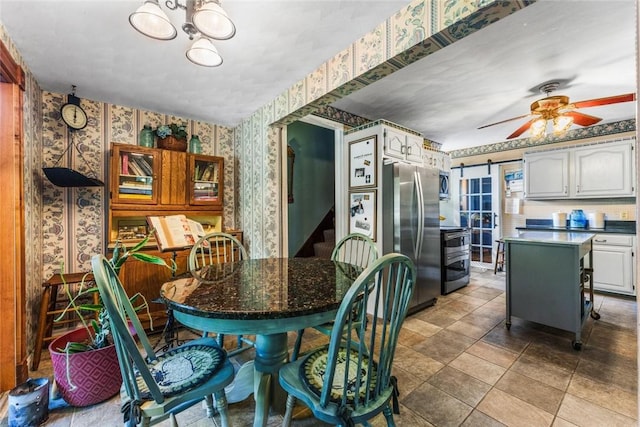 dining space featuring a barn door and ceiling fan