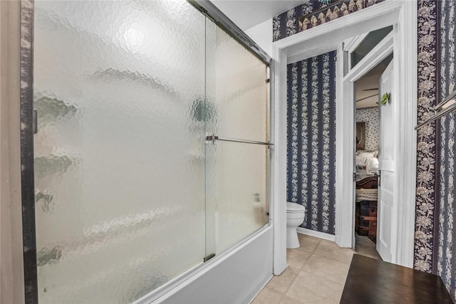 bathroom featuring tile patterned floors, toilet, and combined bath / shower with glass door