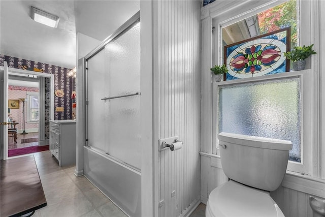 full bathroom featuring combined bath / shower with glass door, vanity, toilet, and tile patterned flooring