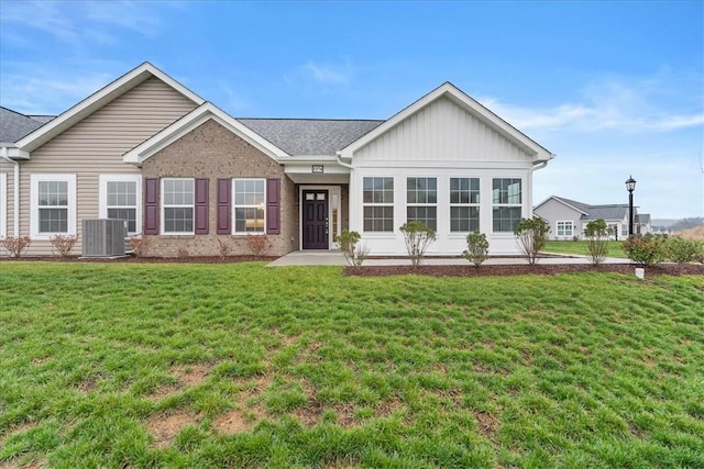 view of front of property featuring cooling unit and a front lawn